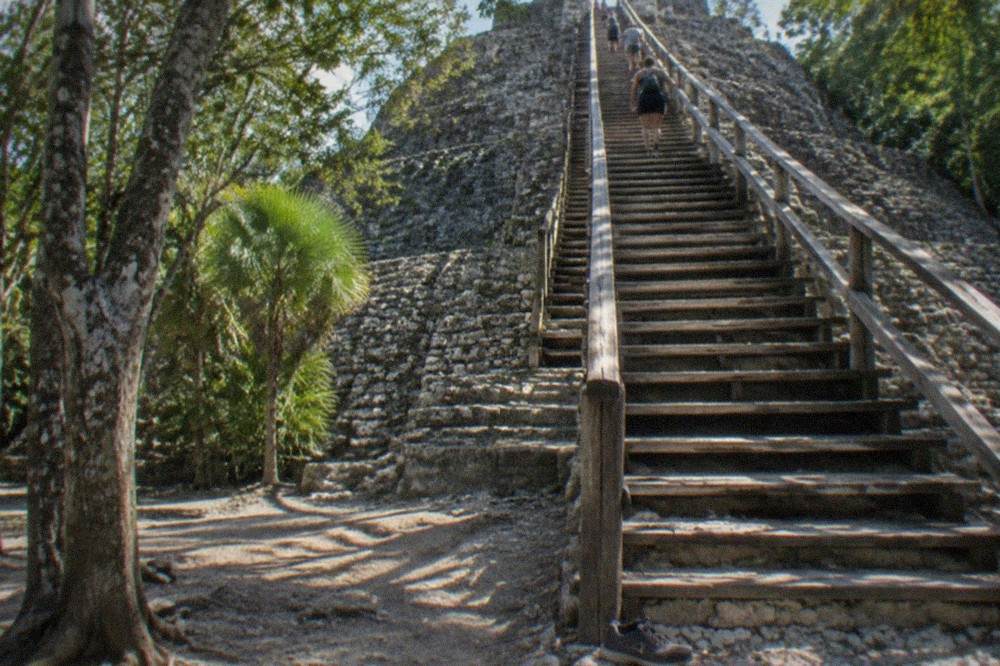 New wooden staircase climbing the side of Nohoch Mul pyramid at Coba archaeological site.
