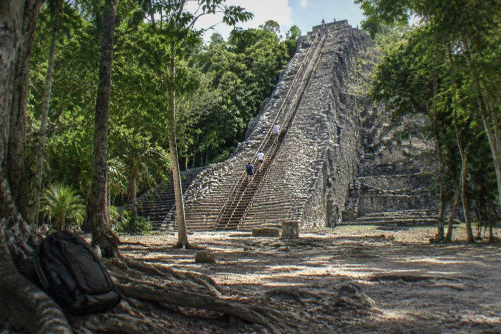 Coba's Nohoch Mul pyramid viewed from the ground with tourists climbing the new staircase.