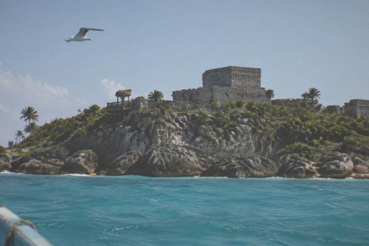 Cliffside Maya ruins overlooking the Caribbean Sea under a clear morning sky