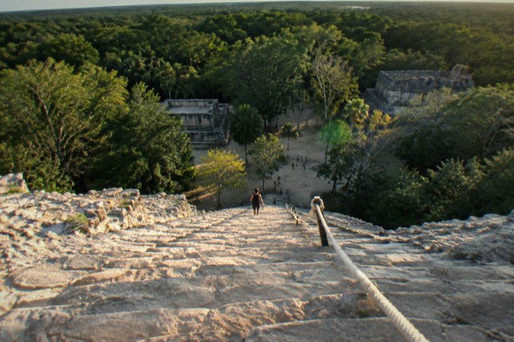 A steep stone staircase on a Mayan acropolis with a rope assist line along one side