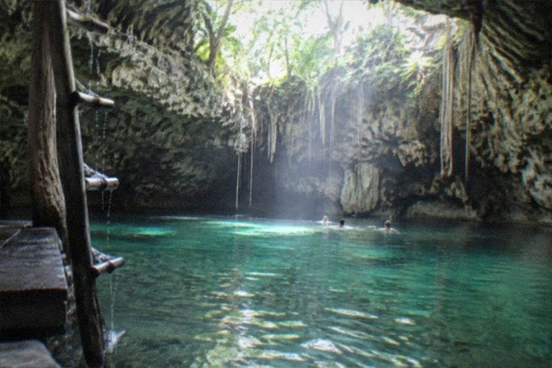 Tulum's Maya ruins paired with a nearby cenote swim stop, clear freshwater ringed by limestone