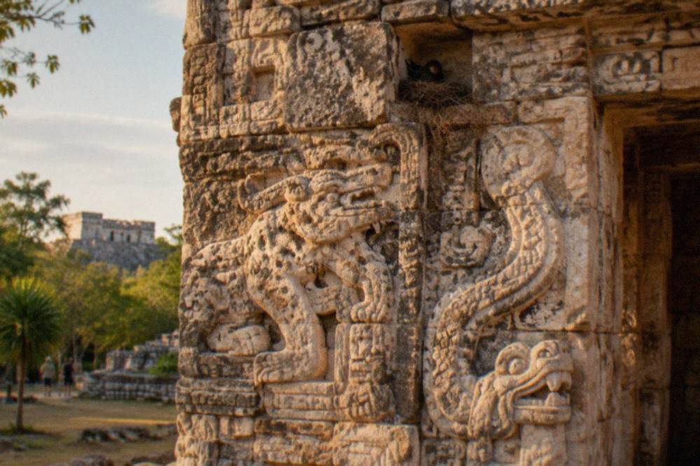 Tall stone Acropolis of Ek Balam with carved facade detail rising above trees