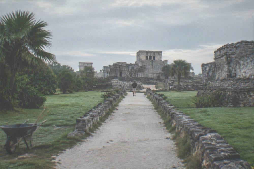 A quiet stone walkway between restored ruins under an early morning sky