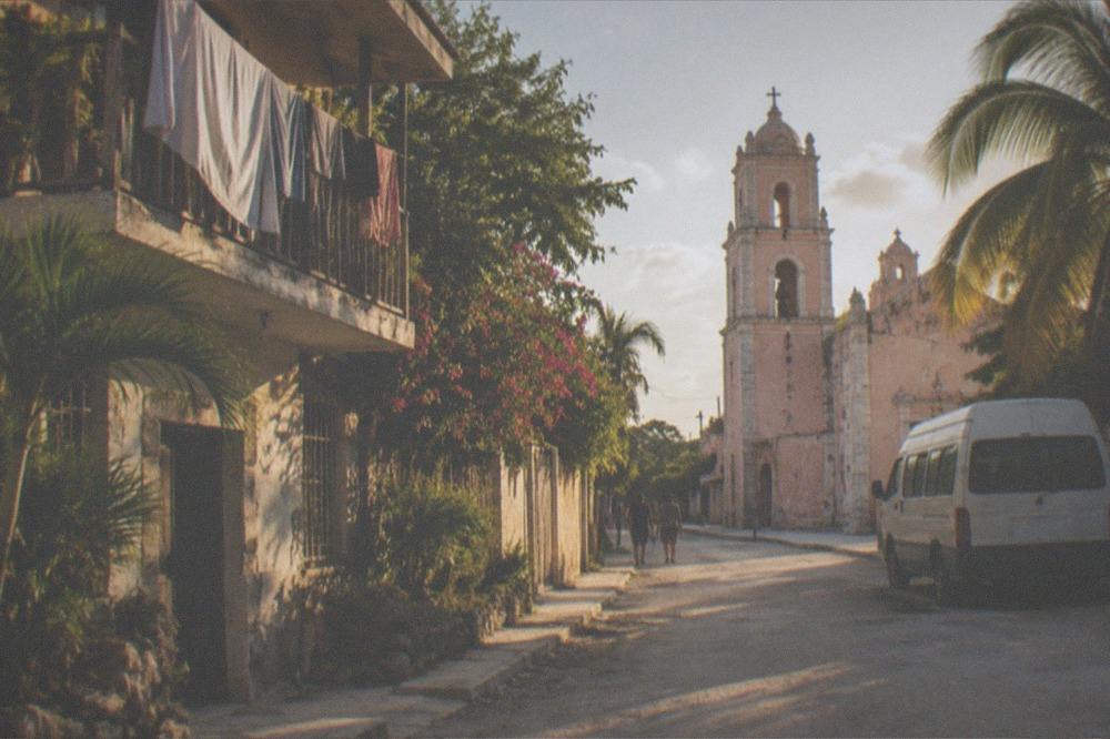 A colonial church facade and quiet street in Valladolid in late afternoon light