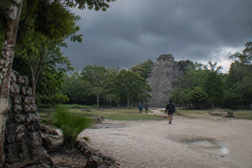 A tall stone Mayan pyramid rising above dense green jungle