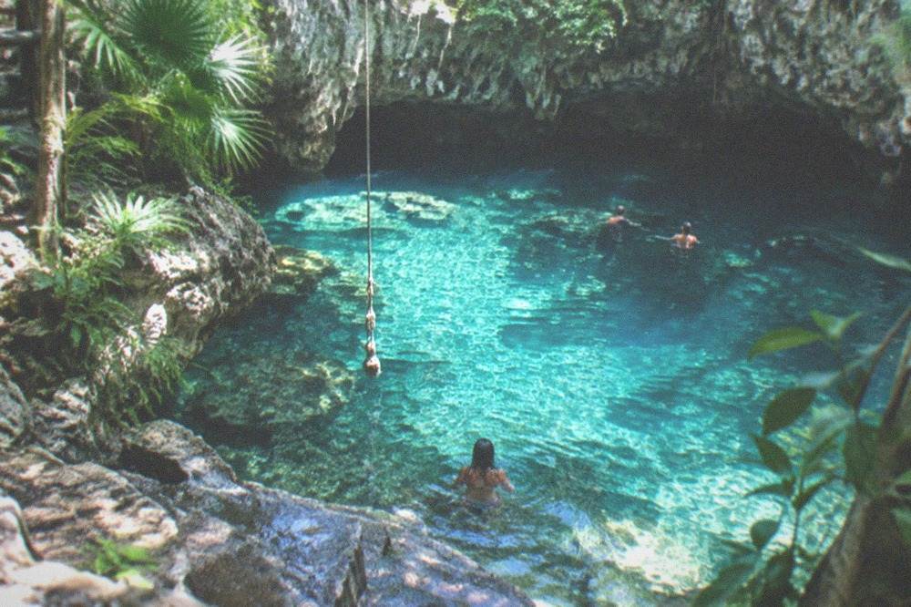 Clear turquoise water in an open jungle cenote near Tulum