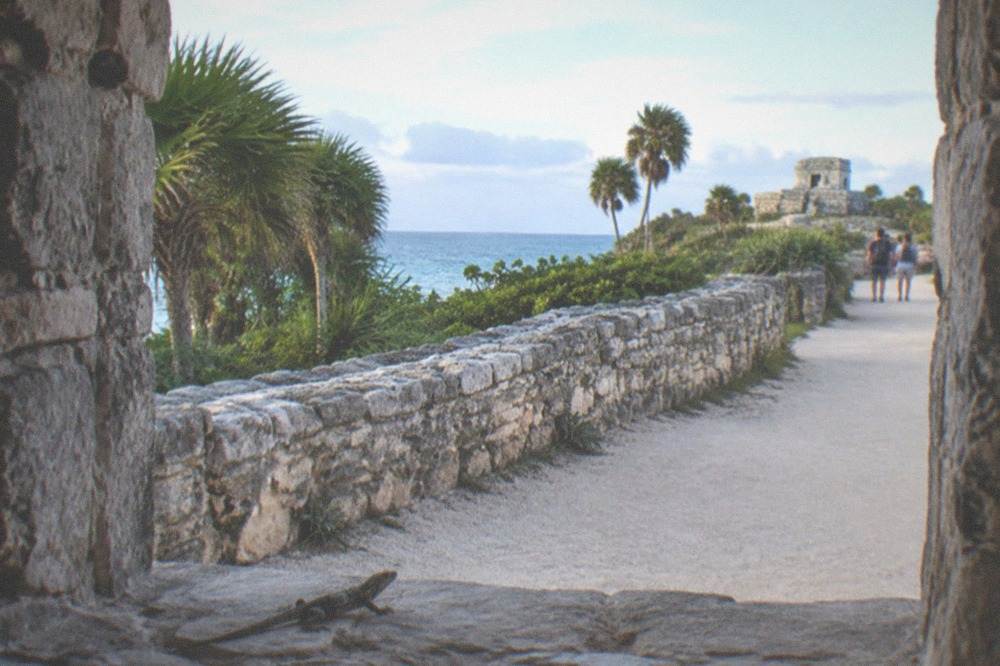 A quiet morning path along a low ancient stone wall with sea visible beyond
