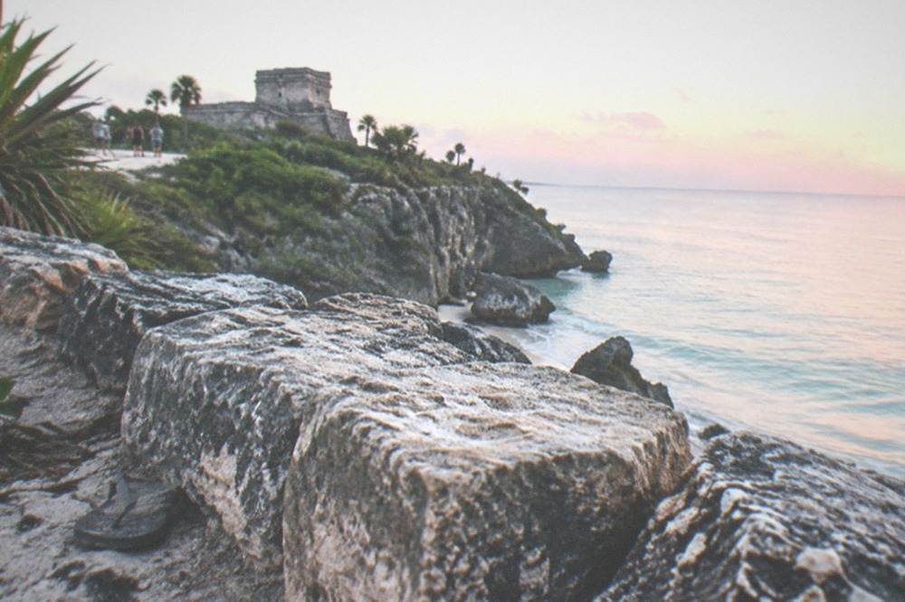 Early morning light on the Tulum ruins sea wall with calm water beyond